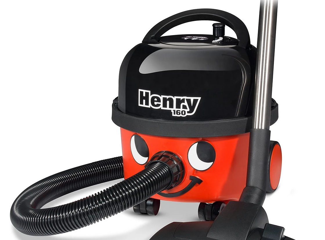 A photo of a red and black Henry hoover, the hoover with a face on it.