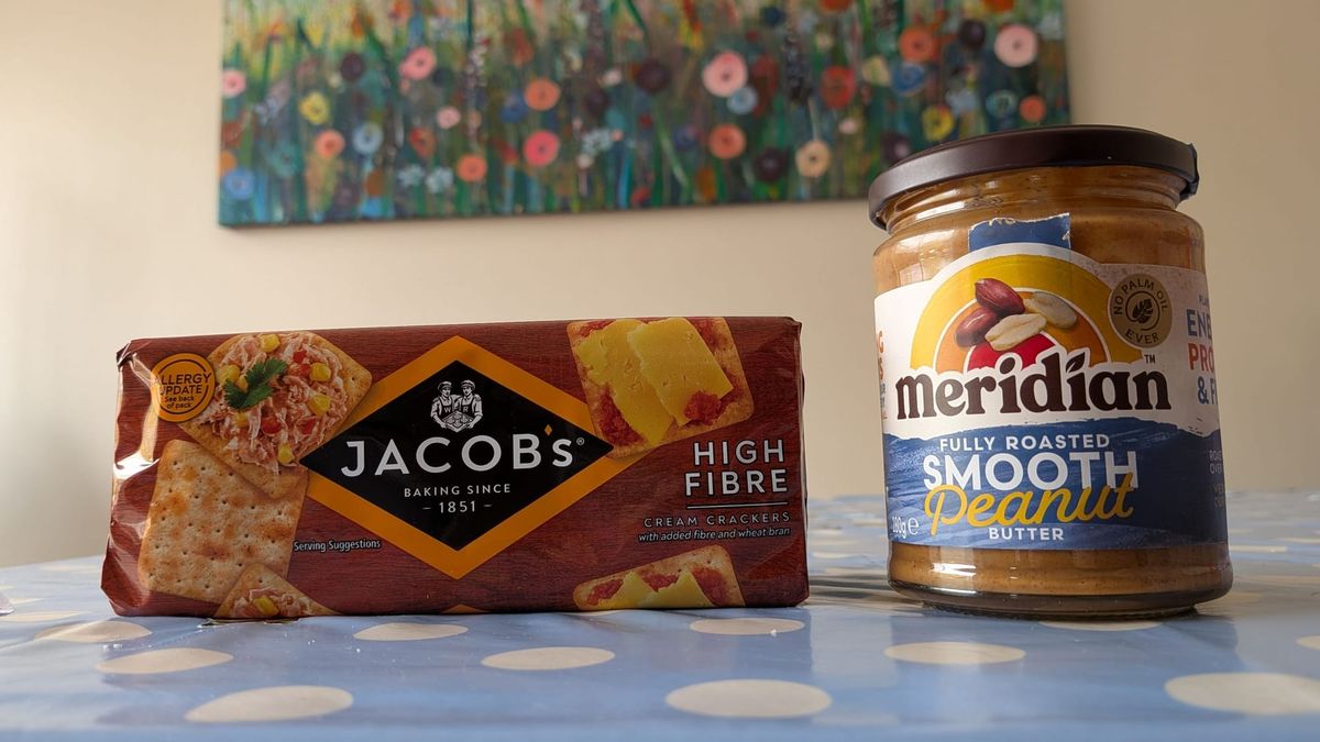 Jacob's high fibre crackers next to some peanut butter, on a table.