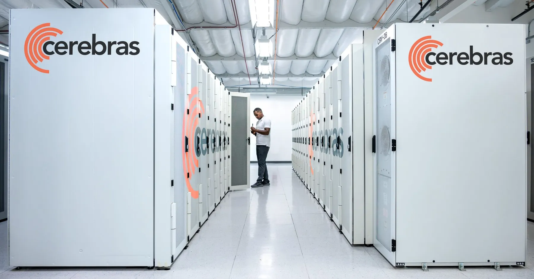 A data center worker examines a server cabinet designed by AI chip startup Cerebras.