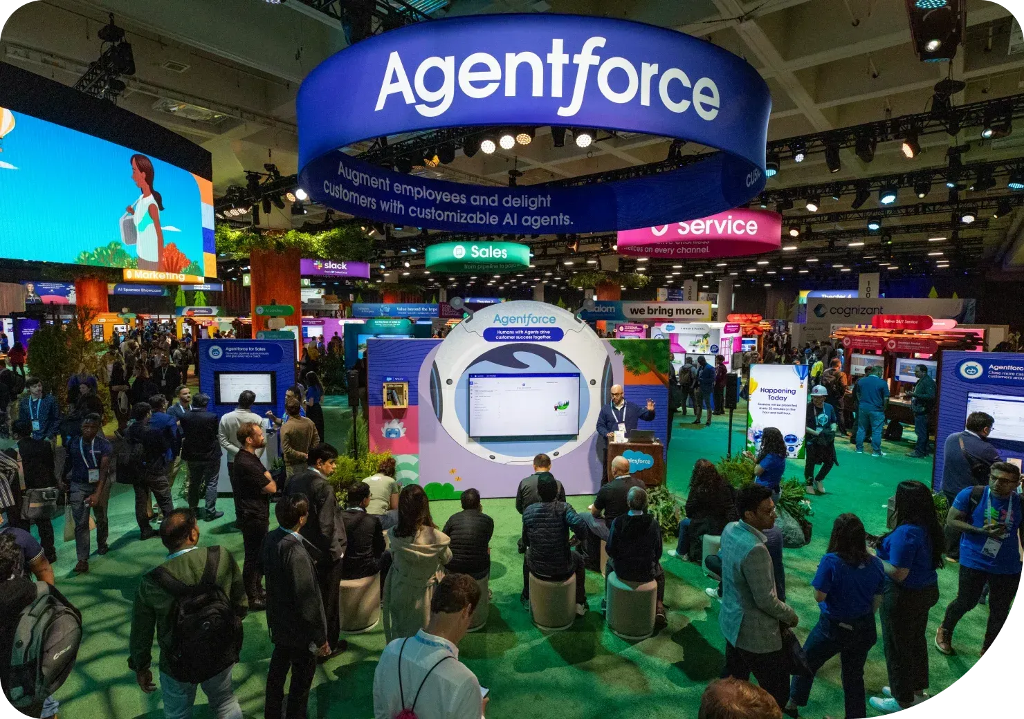 Dozens of Dreamforce 2024 attendees watch a presentation on Agentforce on the floor of the Moscone Convention Center.
