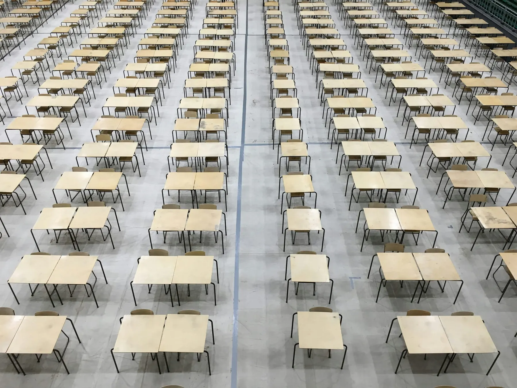 An exam hall with chairs and desks organised in a grid. Microsoft's new AI benchmark framework provides a series of tests to AI models