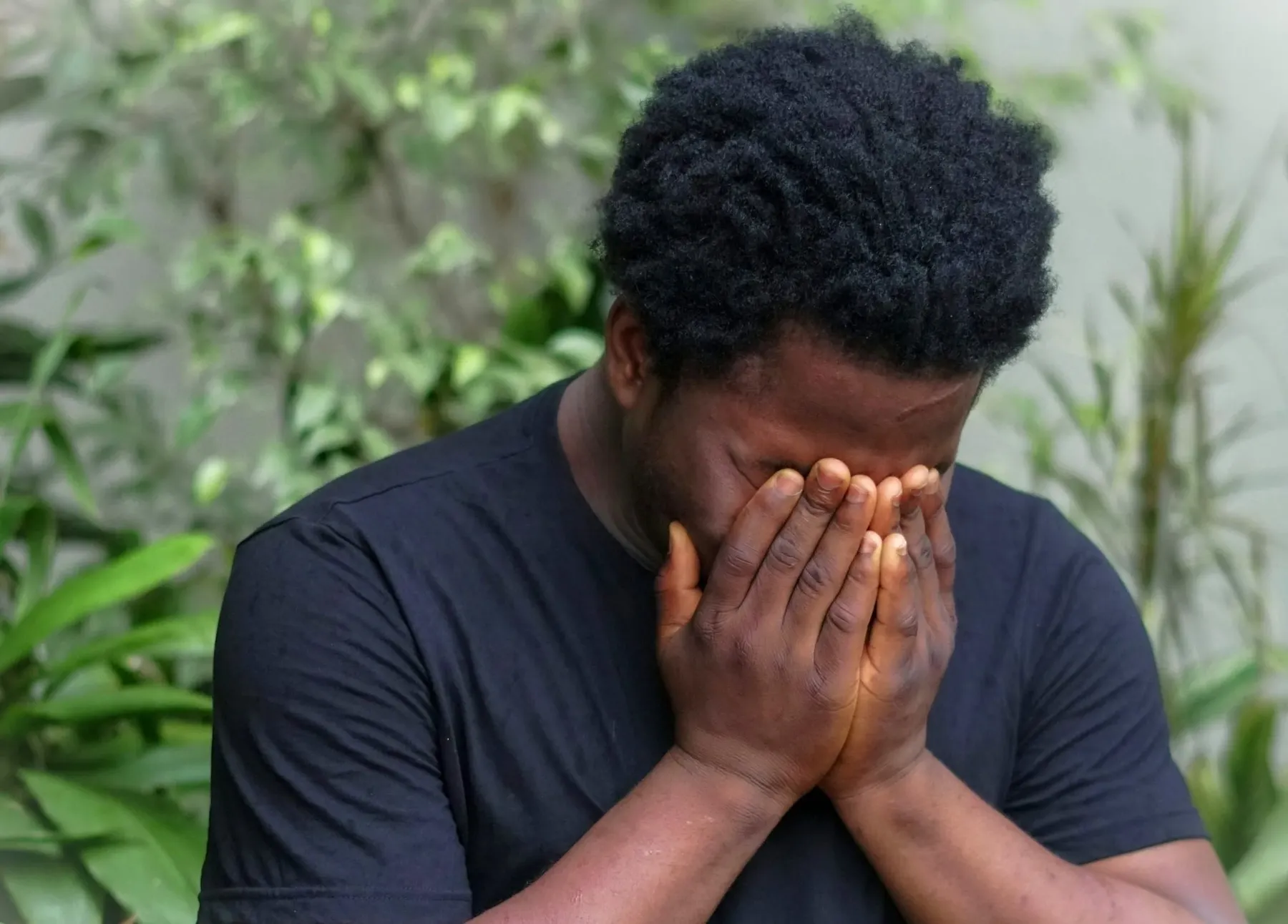 A man with his head in his hands. CISO burnout is a prevalent mental health issue in cybersecurity