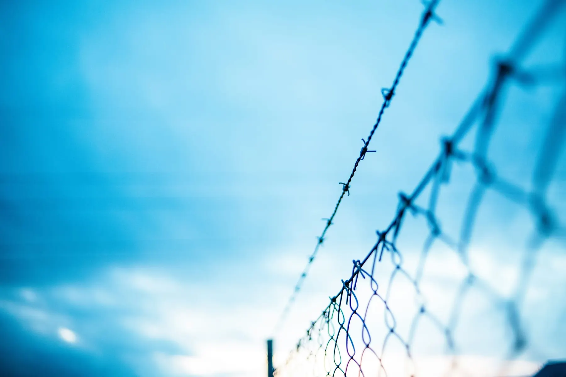 A chain fence with barbed wire, representing the barrier for entry the CMA says cloud hyperscalers have imposed