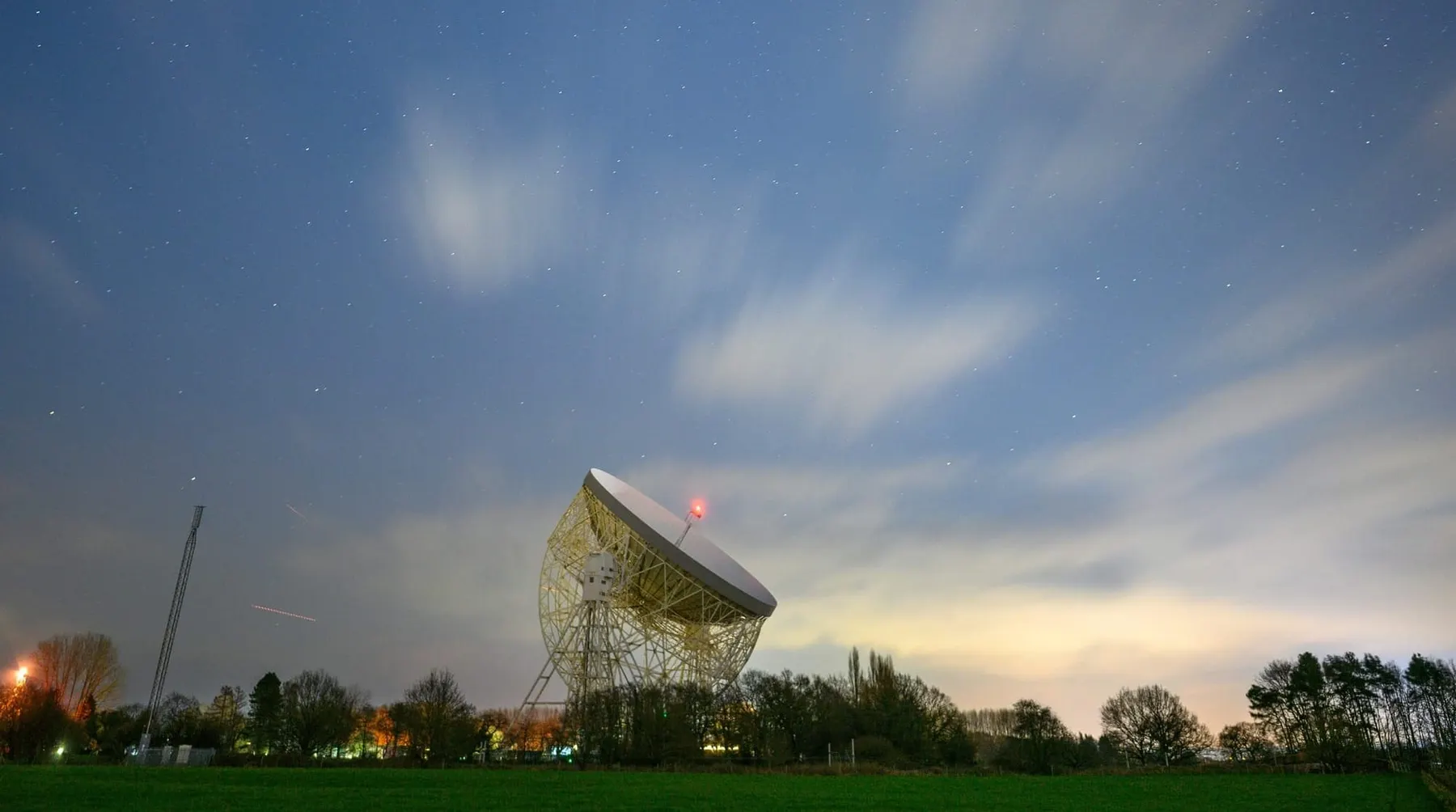 A Jodrell Bank radio telescope at night with bright stars and clouds above. UKSpace Chair Doug Liddle says the UK space sector is ready made for end-to-end operati 