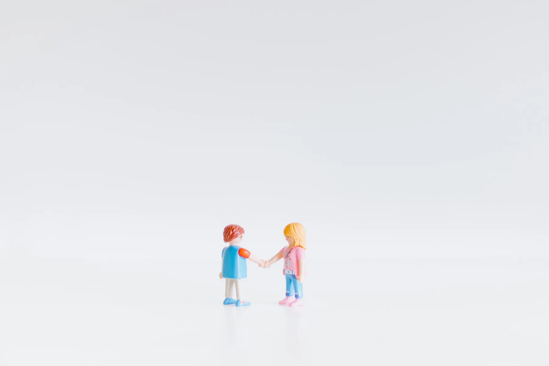 Two playmobil characters set up as if they are shaking hands. Cloudflare's Merkle Tree Certificates will reduce the size of TLS handshakes.