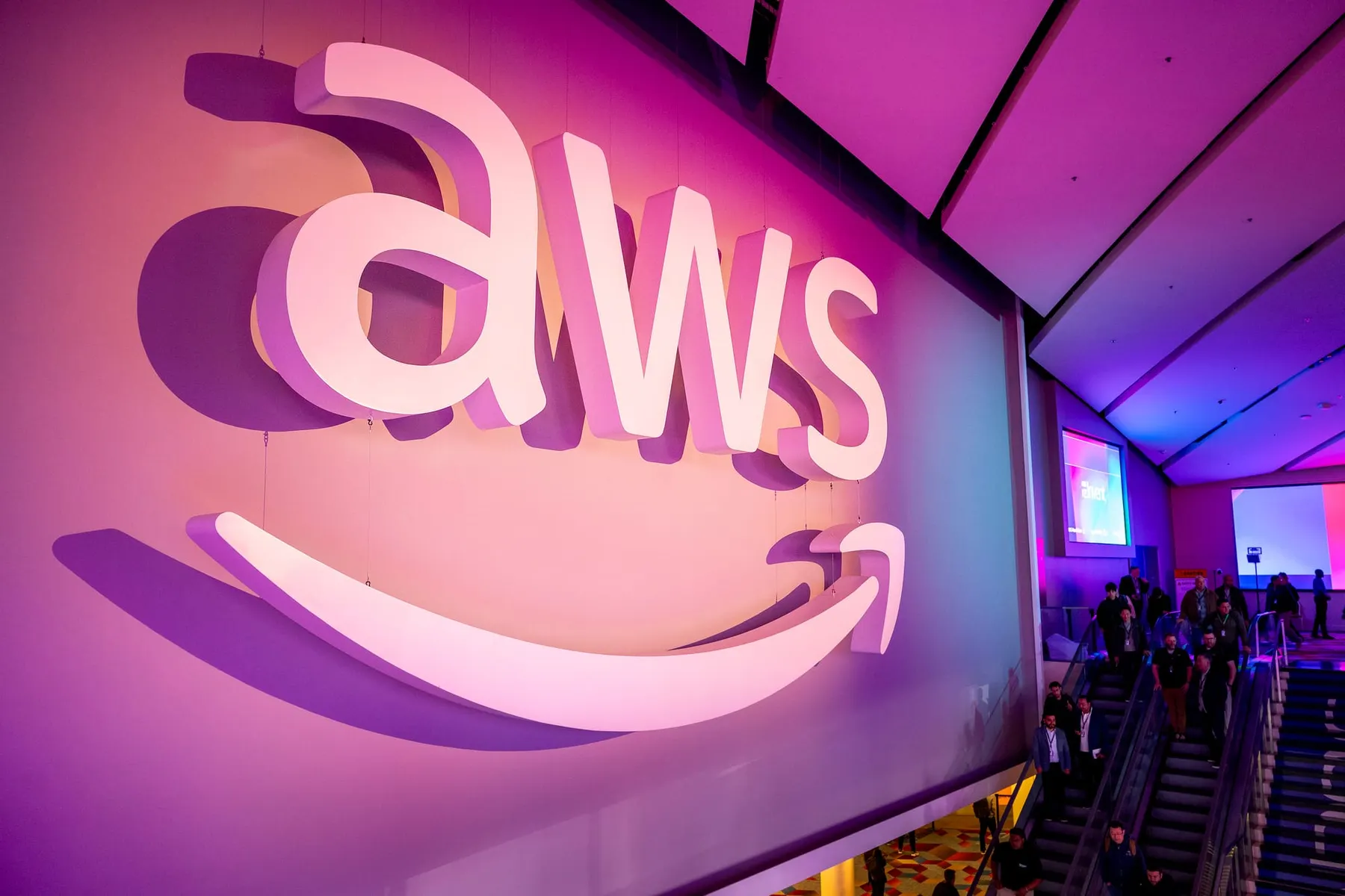 an image of the AWS logo hanging on a wall over an escalator above the expo floor
