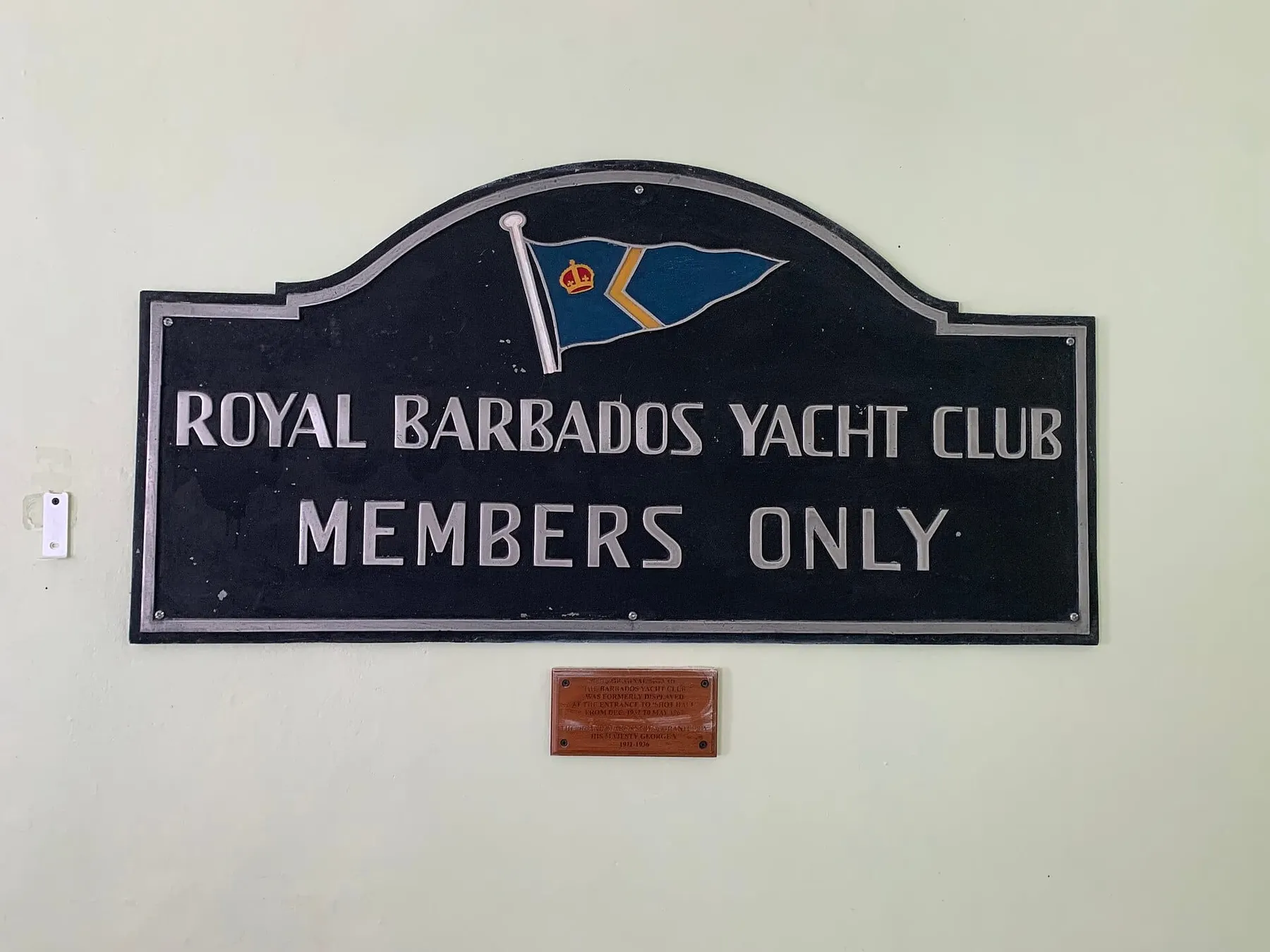A sign on a wall that reads "Royal Barbados Yacht Club, Members Only."