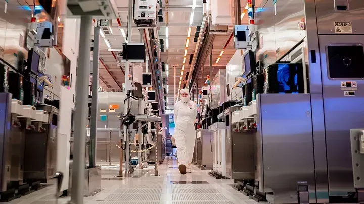 An Intel worker in a bunny suit walks down a hallway in a chip-making plant in Arizona.