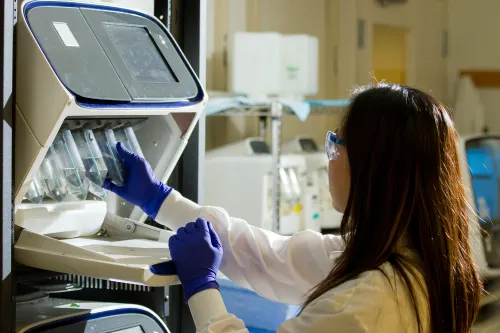 A woman prepares lab equipment for genomic data testing