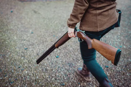 A person walks with a disarmed shotgun in their hand. The National Firearms Licensing Management System tracks all gun licenses in England and Wales