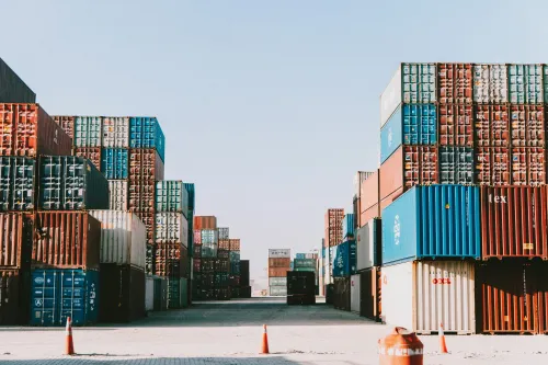 A pile of shipping containers at a port. Apple's new containerization framework offers the ability to run Linux containers on MacOS