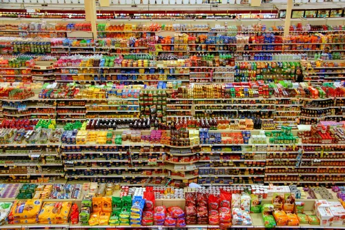 An aerial view of supermarket shelves with thousands of brightly coloured products. AWS will launch its AI Agent marketplace, including Anthropic, on 15 July
