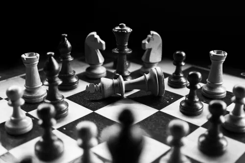 A group of chess pieces arranged on a chess board around a fallen king piece. Operation Checkmate was organised by Europol and US federal agencies