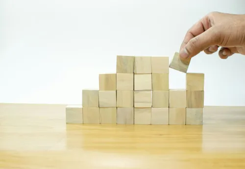 A person stacking wooden blocks. Google's Gemini CLI tool can now build MCP servers quicker through FastMCP