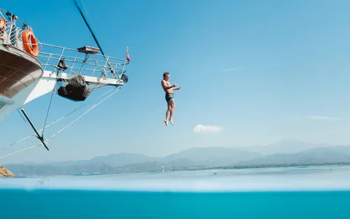 A man jumping into the water off a boat. Some users are leaving GitHub for opensource platforms.