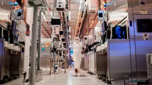 An Intel worker in a bunny suit walks down a hallway in a chip-making plant in Arizona.