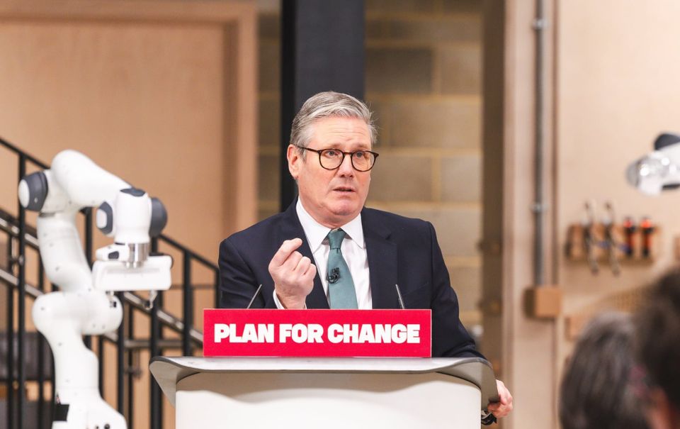 Kier Starmer stands behind a podium reading "plan for change"