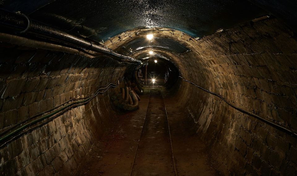 An empty sewer with cables and pipes running along it, Anglian Water will install up to 60,000 sensors in its sewer networ