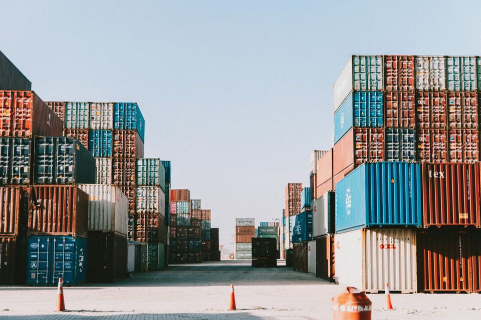 A pile of shipping containers at a port. Apple's new containerization framework offers the ability to run Linux containers on MacOS