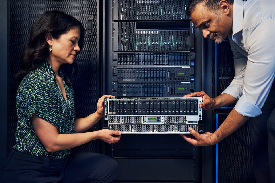 Two people install one of IBM's new Power11 servers in a rack.