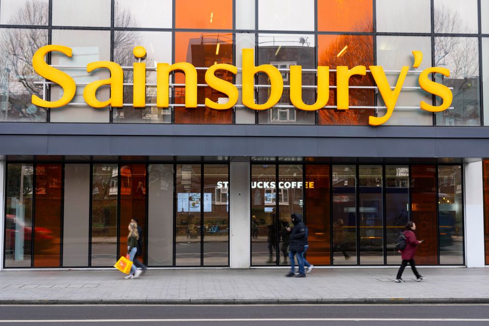 People walk in front of a Sainsbury's supermarket. Sainsbury's is keen to use AI and machine learning to automate its business process but has a cautious approach to retail finance
