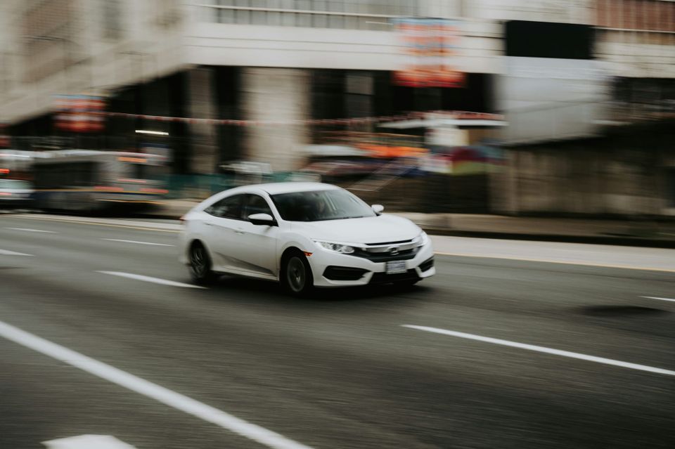 A car moves at speed along a road, the road and streets around it are blurred while the white car is in focus. The FBI and CISA released a joint advisory on the Interlock ransomware group