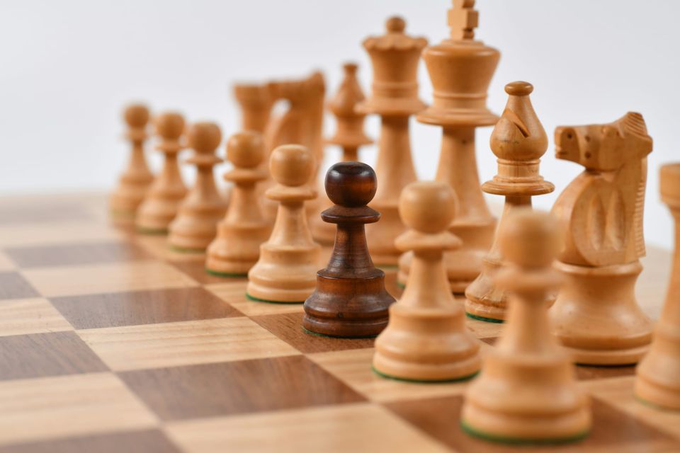 A brown chess piece placed on a board next to all white pieces, the camera is focussed on the brown pawn in the centre. AWS will give its Kiro IDE tool a "unique identity" away from Amazon