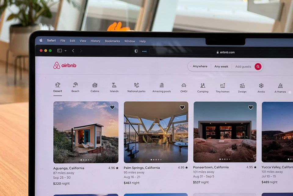 A computer on a web browser showing listings for Airbnb.