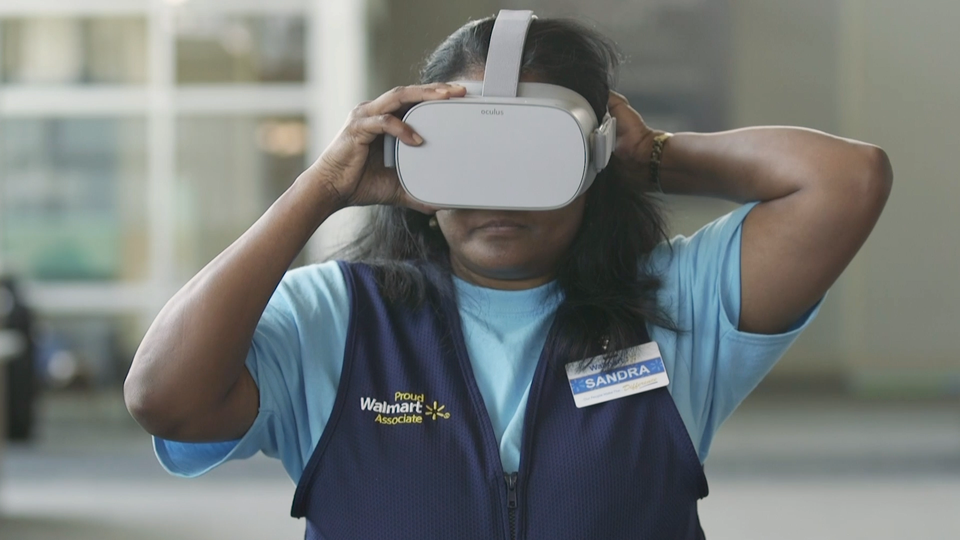 A Walmart employee wearing an Oculus VR headset. Walmart is developing AI super agents.