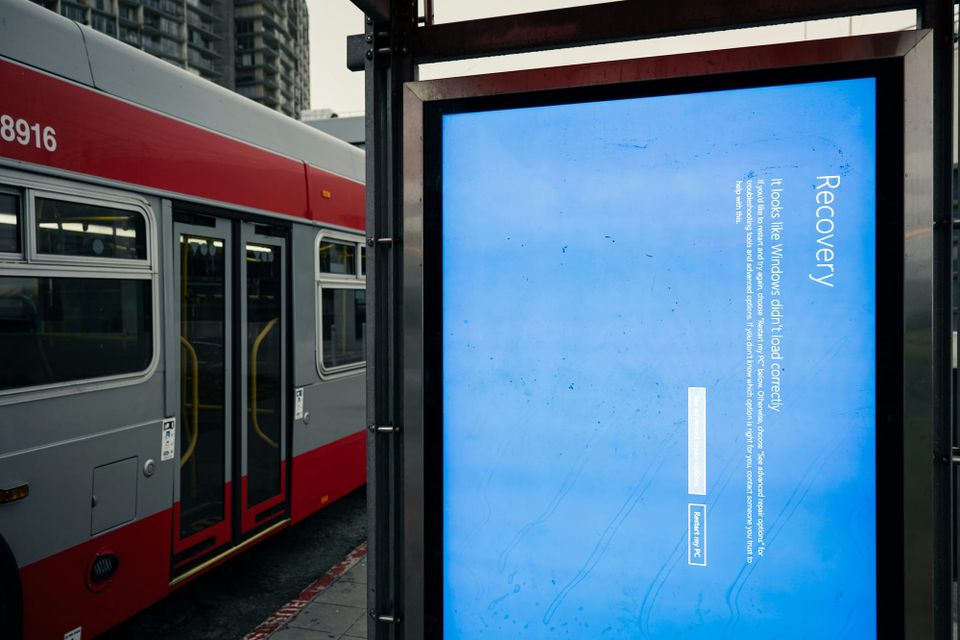 A bus stop advertising screen showing a blue "recovery" window after the Crowdstrike outage in 2024
