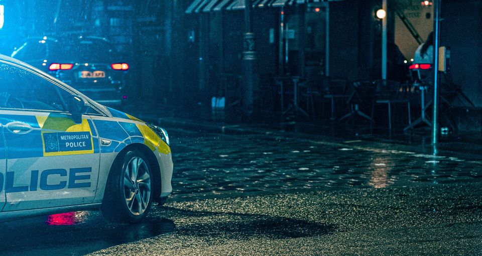 A Metropolitan police car parked outside in the rain