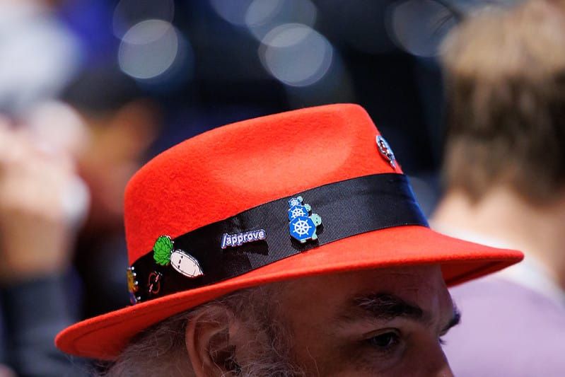 a person wearing a red hat attends kubecon north america in atlanta