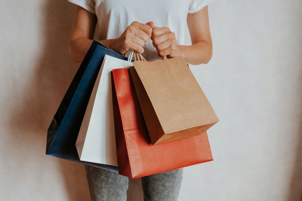 A person holds four shopping bags in their hands. Google launched its Univerisal Commerce Protocol 