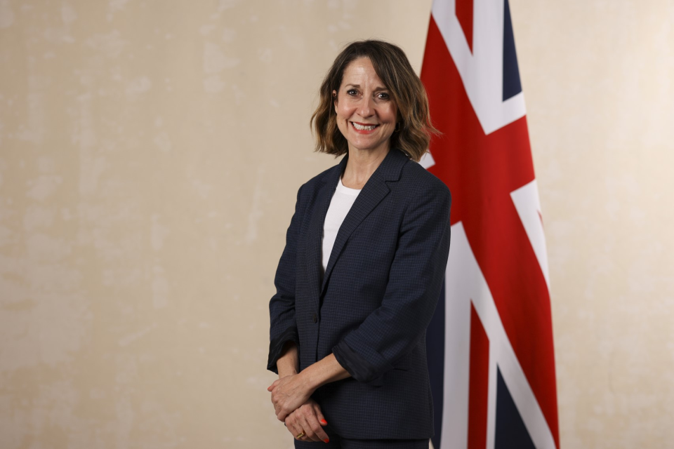 UK Technology Minister Liz Kendall stands in front of a Union Jack flag