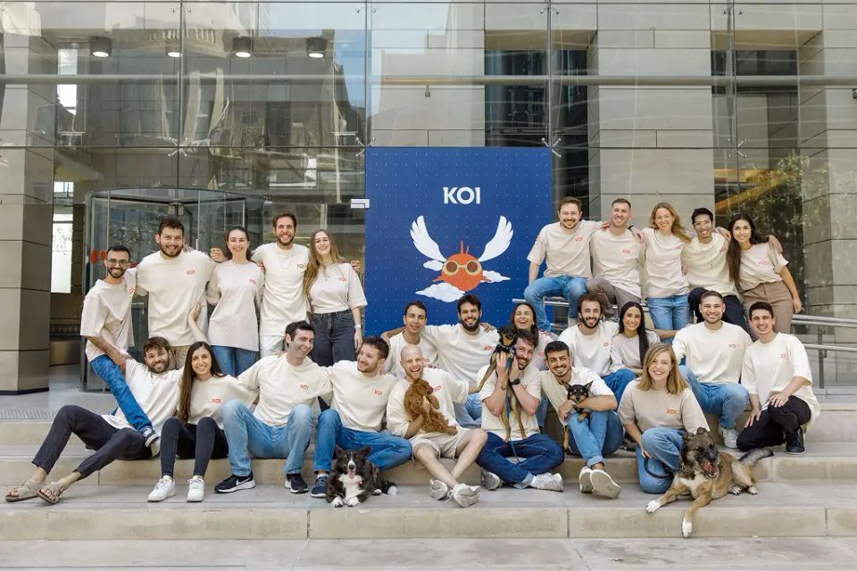 Koi's staff pose in front a Koi sign