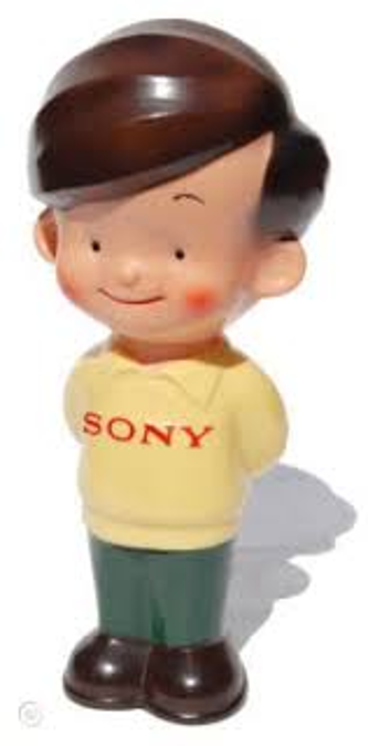 A plastic figure of a young boy in a yellow sweater with the word "Sony"