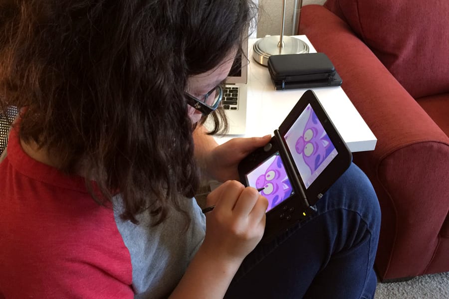 Cookies & Clogs | Video Games | The new Disney Art Academy for Nintendo 3DS has over 80 Disney and Pixar characters to draw and 40 lessons, ranging from starter to advanced. Step-by-step tutorials allow children to learn about the tools, try advanced shapes, practice shading, and master layers. See how my teen daughter enjoyed it in this candid review. Teen girl playing video game.