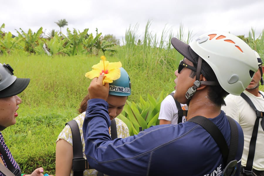 Cookies & Clogs | My first experience with ziplining in Hawaii was with Skyline Eco Adventures Akaka Falls Zipline on the Big Island of Hawaii. See how the quality, safety, and amazing crew won us over. Check out the video of all seven lines! Putting a hibiscus flower in the helmet.