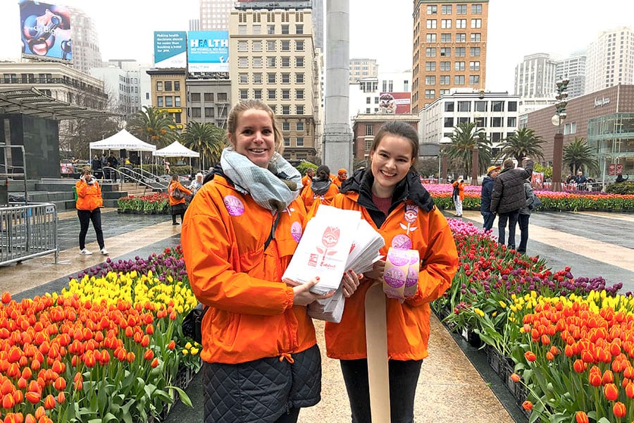 2020 Flower Bulb Day in San Francisco on March 7th! at Union Square in San Francisco on March 7. Photo from 2019 free tulips event Staff in orange with paper bags