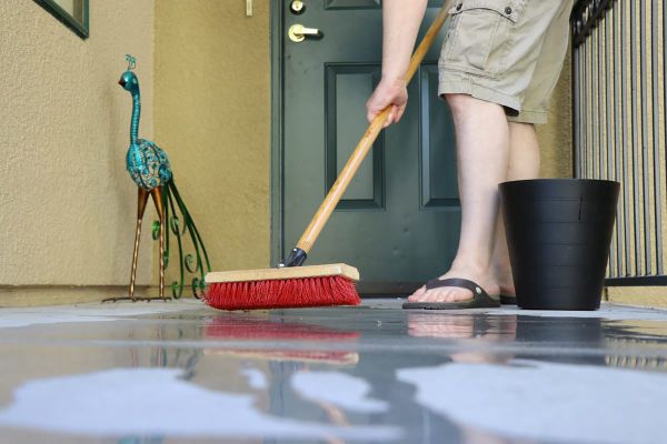 See how to use Clorox bleach for back to school cleaning - scrubbing outside patio with broom.