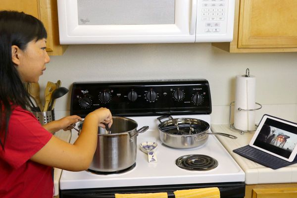 Mom Sneak — Woman cooking while watching Rogue One on Netflix