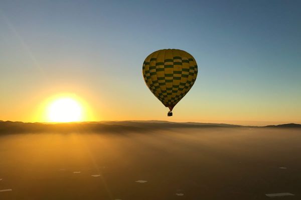 Hot air balloon ride over Napa Valley California at sunrise with clouds