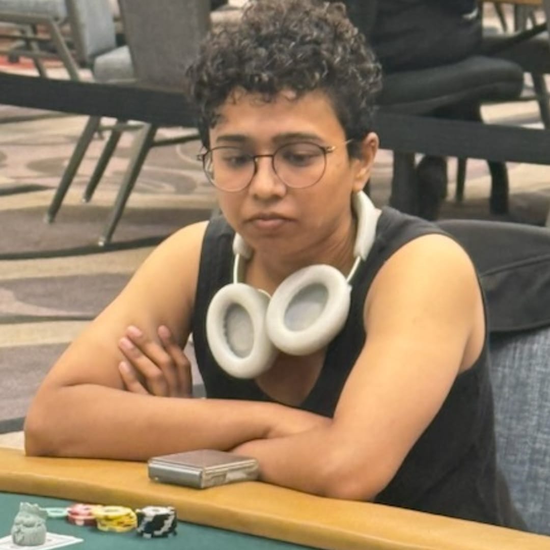 Cheyenne Martins sits focused at the poker table during Day 1b of the 2025 WSOP Monster Stack, wearing headphones around her neck and glasses.