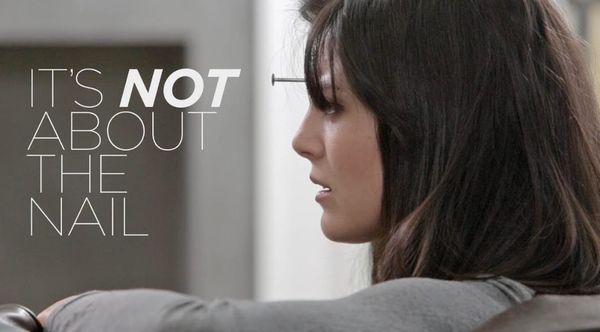 "It's not about the nail" video title page, side back closeup woman on couch leaning over with nail visibly protruding from forehead