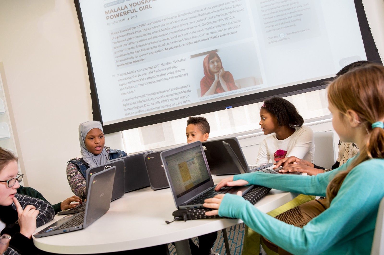 Students discuss CommonLit lesson around table. 