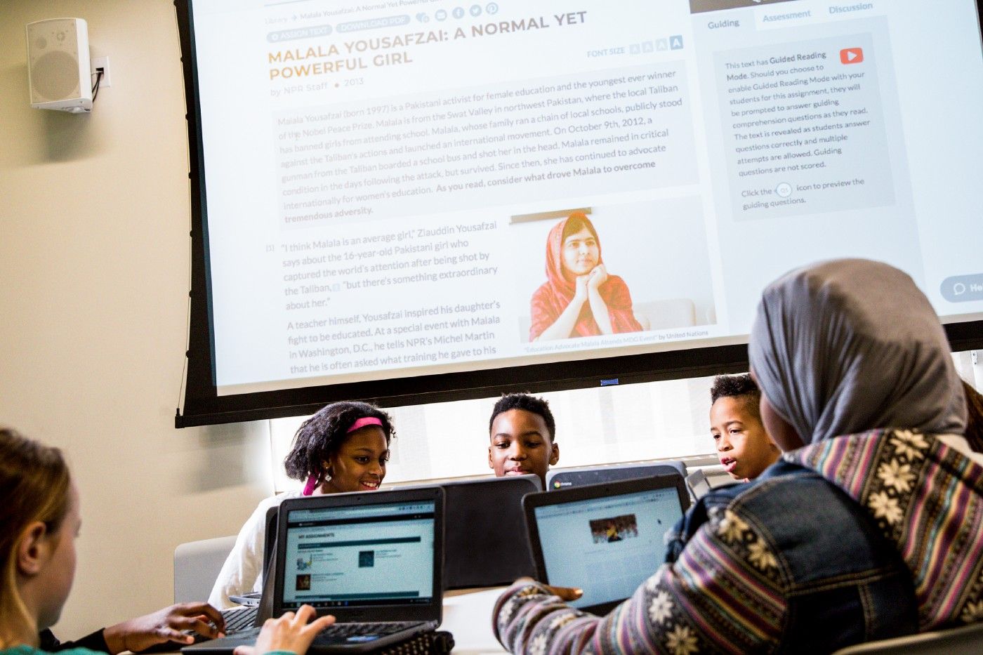 Students look at CommonLit on their laptops. 