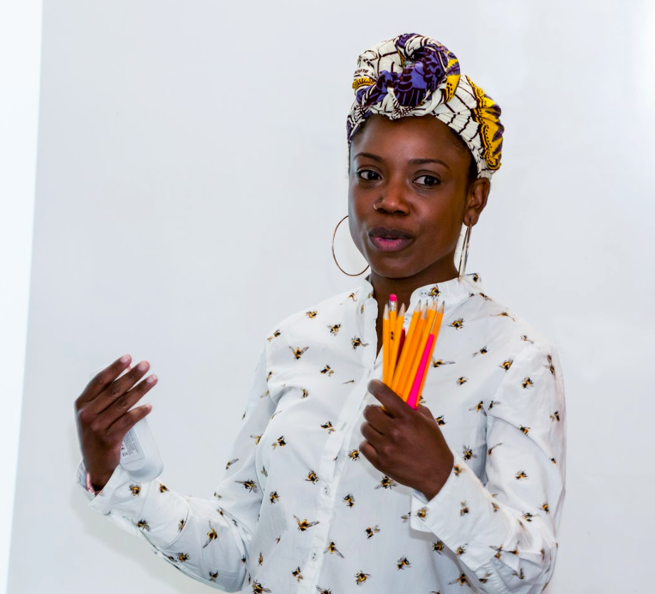 A woman holding pencils and gesturing. 