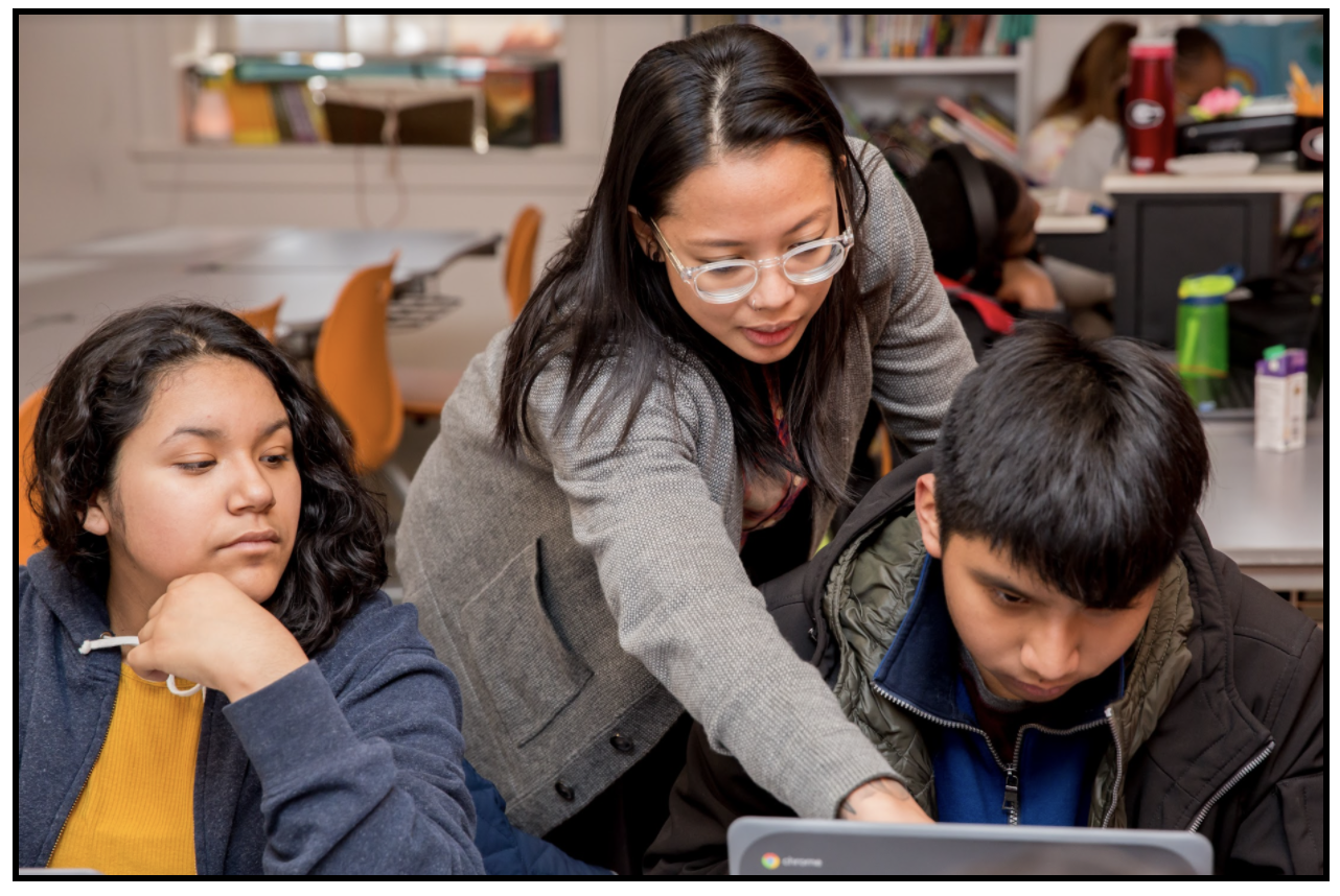 Teacher helps students with lesson. 