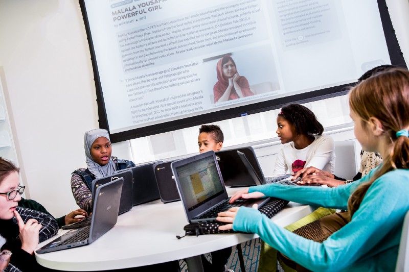 Students looking at their computers and reading CommonLit.org texts. 