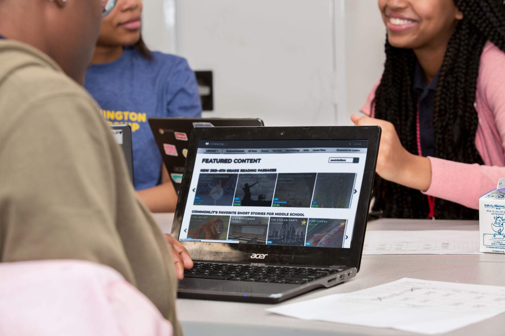 Students work on CommonLit reading lessons on laptops.